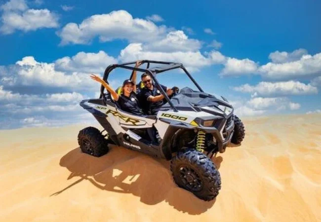 Polaris RZR two-seater dune buggy on the red dunes near Dubai