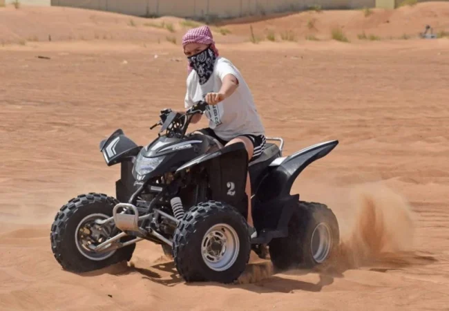 Yamaha 220cc beginner ATV parked on the red sand at Al Lahbab